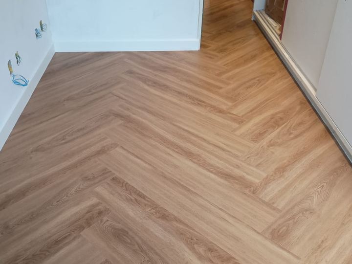 Piso laminado em espinha de peixe instalado em quarto pela Camargão Pisos